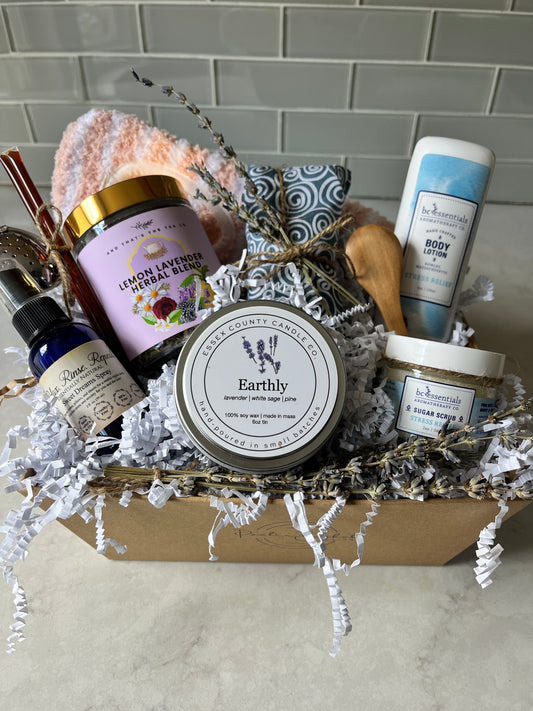"Bliss Basket with lavender eye pillow, lavender spray, sugar scrub, body lotion, sage candle, lemon lavender tea, honey, and slipper socks"